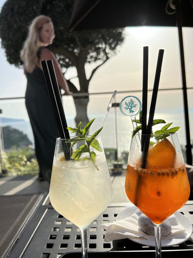 Two Aperol spritzes with an Amalfi Coast sea view