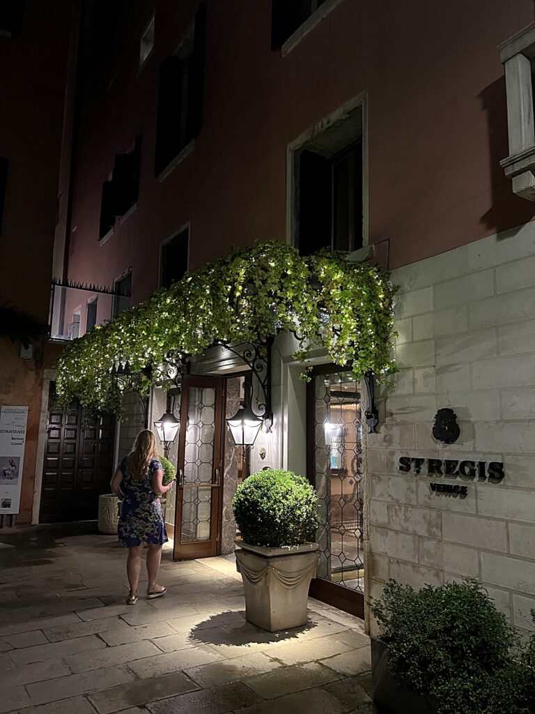Entrance of the St. Regis Venice hotel dressed in greenery at night