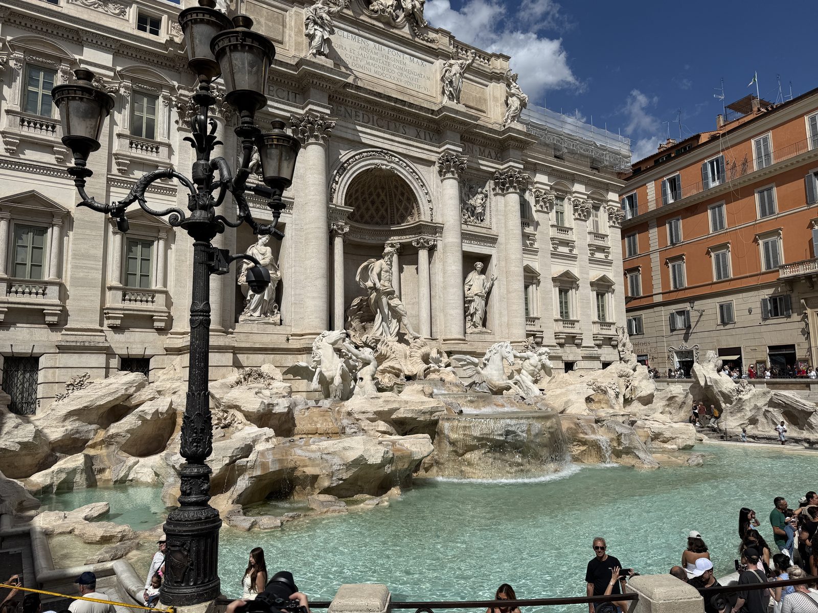 The Trevi Fountain and the crowd in front of it on a sunny afternoon in Rome