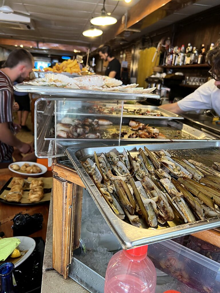 Cicchetti counter at a Venetian bacaro piled with trays of fried seafood and small bites